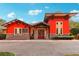 Exterior of community activity center with vibrant red accents, stone details, and inviting double-door entrance at 26821 Augusta Springs Cir, Leesburg, FL 34748