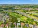 Panoramic aerial view of a community with well-manicured lawns, a golf course, and scenic surroundings at 26821 Augusta Springs Cir, Leesburg, FL 34748