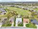 Aerial view of the home in relation to a golf course, pond, and surrounding homes at 26821 Augusta Springs Cir, Leesburg, FL 34748