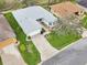 Aerial view of a gray roofed home features a manicured lawn and established landscaping at 26821 Augusta Springs Cir, Leesburg, FL 34748