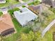 Aerial view of a home with a well-maintained lawn, mature trees, and proximity to a sidewalk at 26821 Augusta Springs Cir, Leesburg, FL 34748