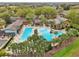 Aerial view of a community pool and clubhouse surrounded by lush landscaping at 26821 Augusta Springs Cir, Leesburg, FL 34748