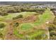 An aerial view of a golf course featuring sand traps and undulating greens at 26821 Augusta Springs Cir, Leesburg, FL 34748