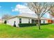 Manicured backyard of home, featuring a well-maintained lawn and privacy hedges at 26821 Augusta Springs Cir, Leesburg, FL 34748