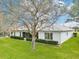 A white home surrounded by greenery, emphasizing the peaceful backyard with green landscaping and trees at 26821 Augusta Springs Cir, Leesburg, FL 34748