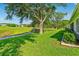 Expansive backyard with lush green grass and mature trees, offering serene views of the golf course at 26821 Augusta Springs Cir, Leesburg, FL 34748
