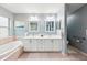 Bright bathroom featuring double vanity, soaking tub, and decorative light fixtures at 26821 Augusta Springs Cir, Leesburg, FL 34748