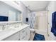 Bathroom showcasing a double sink vanity and bath with blue accents at 26821 Augusta Springs Cir, Leesburg, FL 34748