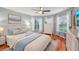 A well-lit bedroom with hardwood floors, a ceiling fan, and a serene bay window at 26821 Augusta Springs Cir, Leesburg, FL 34748