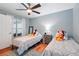 ' bedroom featuring two twin beds, a ceiling fan, a patterned rug, and a window at 26821 Augusta Springs Cir, Leesburg, FL 34748