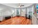 Bedroom with hardwood floors, ceiling fan, and bay window dressed with white drapes at 26821 Augusta Springs Cir, Leesburg, FL 34748