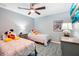 ' bedroom with two twin beds, a ceiling fan, a blue rug, and a nightstand at 26821 Augusta Springs Cir, Leesburg, FL 34748