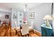 Bright and airy dining room featuring a modern glass table and four white chairs at 26821 Augusta Springs Cir, Leesburg, FL 34748