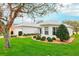 Home exterior featuring a well-kept lawn and meticulously trimmed shrubbery at 26821 Augusta Springs Cir, Leesburg, FL 34748