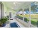 Enclosed lanai featuring ceiling fans, comfortable seating, and views of the lush landscape and golf course at 26821 Augusta Springs Cir, Leesburg, FL 34748