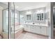 Bright bathroom featuring a soaking tub, a glass enclosed shower, and double sinks set in white cabinets at 26821 Augusta Springs Cir, Leesburg, FL 34748