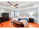 Comfortable main bedroom featuring hardwood floors, dark wood furniture, and a ceiling fan for added comfort at 26821 Augusta Springs Cir, Leesburg, FL 34748