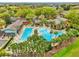 Aerial view of a luxurious community pool area surrounded by lush landscaping and comfortable seating at 26821 Augusta Springs Cir, Leesburg, FL 34748