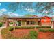 Exterior of a community building, Village Green, with manicured landscaping and colorful facade at 26821 Augusta Springs Cir, Leesburg, FL 34748