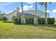 The backyard showcases a screened pool enclosure, lush greenery, and mature palm trees at 288 Bent Oak Ct, Leesburg, FL 34748