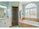 Bright bathroom features a soaking tub, glass-enclosed shower, and a large arched window at 288 Bent Oak Ct, Leesburg, FL 34748