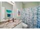 Bathroom with a patterned shower curtain, tile floor, and a vanity with marble countertop at 288 Bent Oak Ct, Leesburg, FL 34748