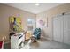 Small bedroom with neutral walls, carpet, desk, and colorful wall art at 288 Bent Oak Ct, Leesburg, FL 34748