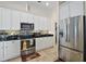 Updated kitchen featuring modern appliances, mosaic backsplash, and stylish white cabinetry at 288 Bent Oak Ct, Leesburg, FL 34748