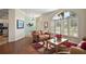 Cozy living room featuring hardwood floors, large windows with plantation shutters, and elegant decor at 288 Bent Oak Ct, Leesburg, FL 34748