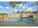 Screened pool with water, inflatables, and pool furniture in a patio surrounded by palm trees and partial screening at 288 Bent Oak Ct, Leesburg, FL 34748