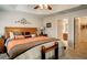 Comfortable main bedroom featuring a tray ceiling, ceiling fan, and an ensuite bathroom at 3076 Gulfport Ct, The Villages, FL 32163