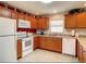 A cozy kitchen with wooden cabinets, white appliances, and ample counter space at 3076 Gulfport Ct, The Villages, FL 32163