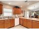 Bright kitchen featuring wood cabinetry, white appliances, and a large countertop space at 3076 Gulfport Ct, The Villages, FL 32163