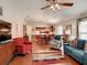 Open-concept living room featuring hardwood floors, vaulted ceiling with fan, and seamless flow into the adjacent kitchen at 3076 Gulfport Ct, The Villages, FL 32163