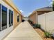 Side patio featuring walkway between two homes with manicured landscaping at 3076 Gulfport Ct, The Villages, FL 32163