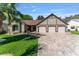 Charming single-Gathering home with a paver driveway, three-car garage and manicured front lawn with palm tree at 314 Chula Vista Ave, Lady Lake, FL 32159