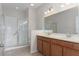 Bathroom with a walk-in glass shower and double vanity with neutral countertops and wooden cabinets at 3201 Sonesta Ct # B, Clermont, FL 34711