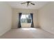 Bright bedroom with ceiling fan and window offering a view of the outdoors with blue curtains at 3201 Sonesta Ct # B, Clermont, FL 34711