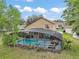 Aerial view of a screened-in pool with patio furniture, a spa, and a well-kept yard at 3320 Callerton Rd, Clermont, FL 34714