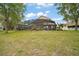 Expansive backyard featuring a screened-in patio, lush lawn, and mature trees, perfect for outdoor relaxation at 3320 Callerton Rd, Clermont, FL 34714