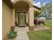 Inviting front porch with decorative plants, a wreath on the door, and a charming light fixture at 3320 Callerton Rd, Clermont, FL 34714