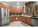 Modern kitchen featuring stainless steel appliances, wooden cabinetry, and an elegant tile backsplash at 3320 Callerton Rd, Clermont, FL 34714