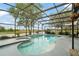 Enclosed pool area with a hot tub and views of the surrounding landscape at 3320 Callerton Rd, Clermont, FL 34714