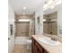 Tiled bathroom features a tub and a large vanity with storage at 3403 Rabbit Run Path, The Villages, FL 32163