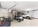 Well-organized garage space featuring storage, a golf cart, and parking for a vehicle at 3403 Rabbit Run Path, The Villages, FL 32163