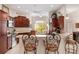 Kitchen featuring warm wood cabinetry, bar seating, and a view of the outdoors at 3403 Rabbit Run Path, The Villages, FL 32163