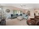 Bright living room with vaulted ceilings, ceiling fan, and sliding glass doors to the lanai at 3403 Rabbit Run Path, The Villages, FL 32163