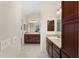 Hallway view of the main bathroom featuring double sinks, vanities, and tiled floors at 3403 Rabbit Run Path, The Villages, FL 32163