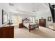 Spacious main bedroom with ceiling fan, tray ceiling, large windows, and neutral carpet at 3403 Rabbit Run Path, The Villages, FL 32163