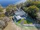 An aerial view shows the house surrounded by lush trees, a lake, and pool offering seclusion and beauty at 36014 Poinsettia Ave, Fruitland Park, FL 34731